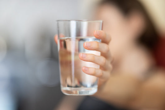woman holding a cup of clear water